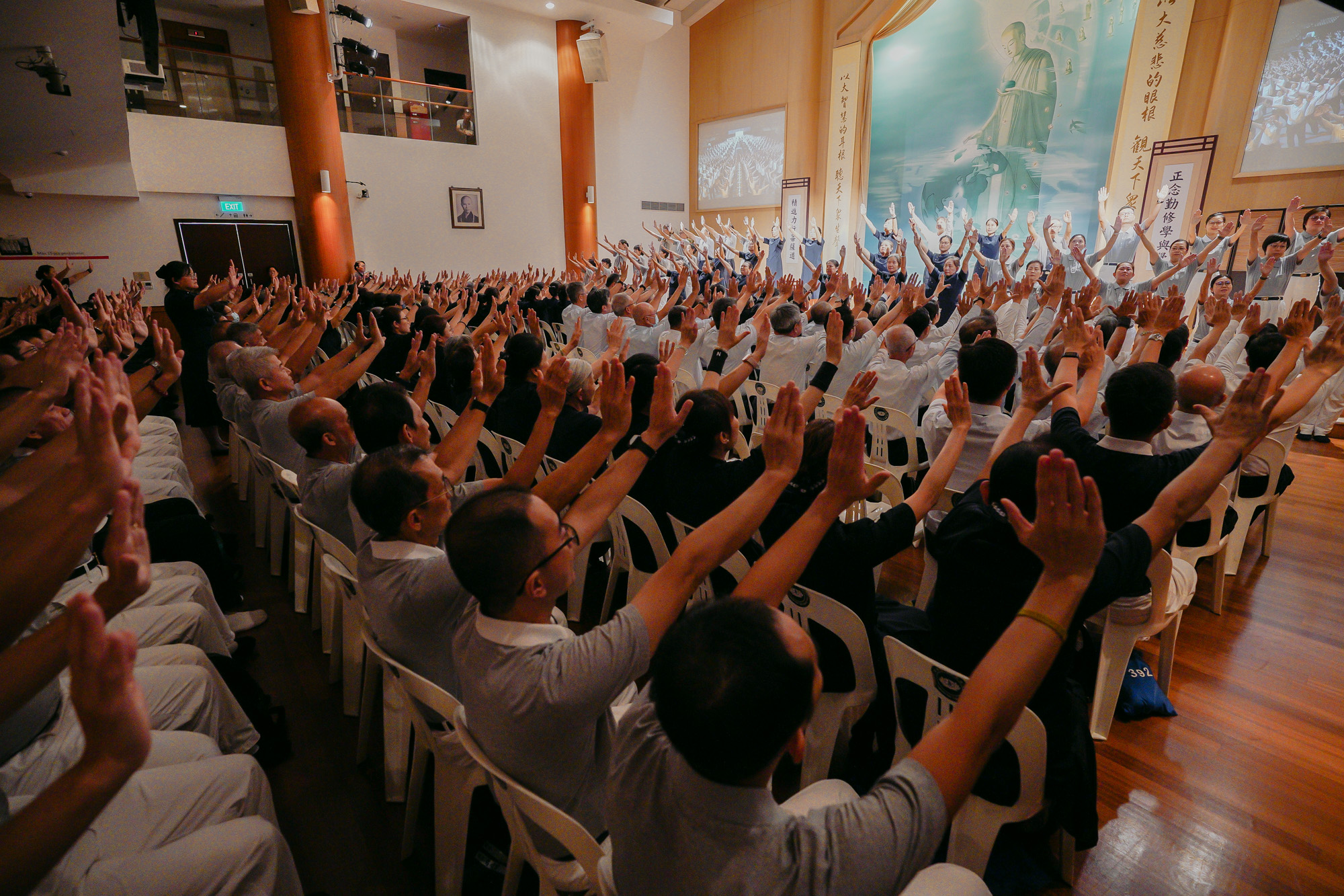 志工在台上演绎，台下的观众举起双手给予回应，场面温馨感动。摄/ 林春慧