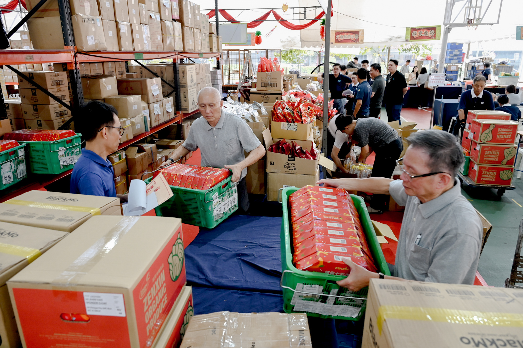 Behind the bustling stalls are volunteers quietly working hard, delivering goods and keeping everything running smoothly. (Photo by Pua Poo Toong)  