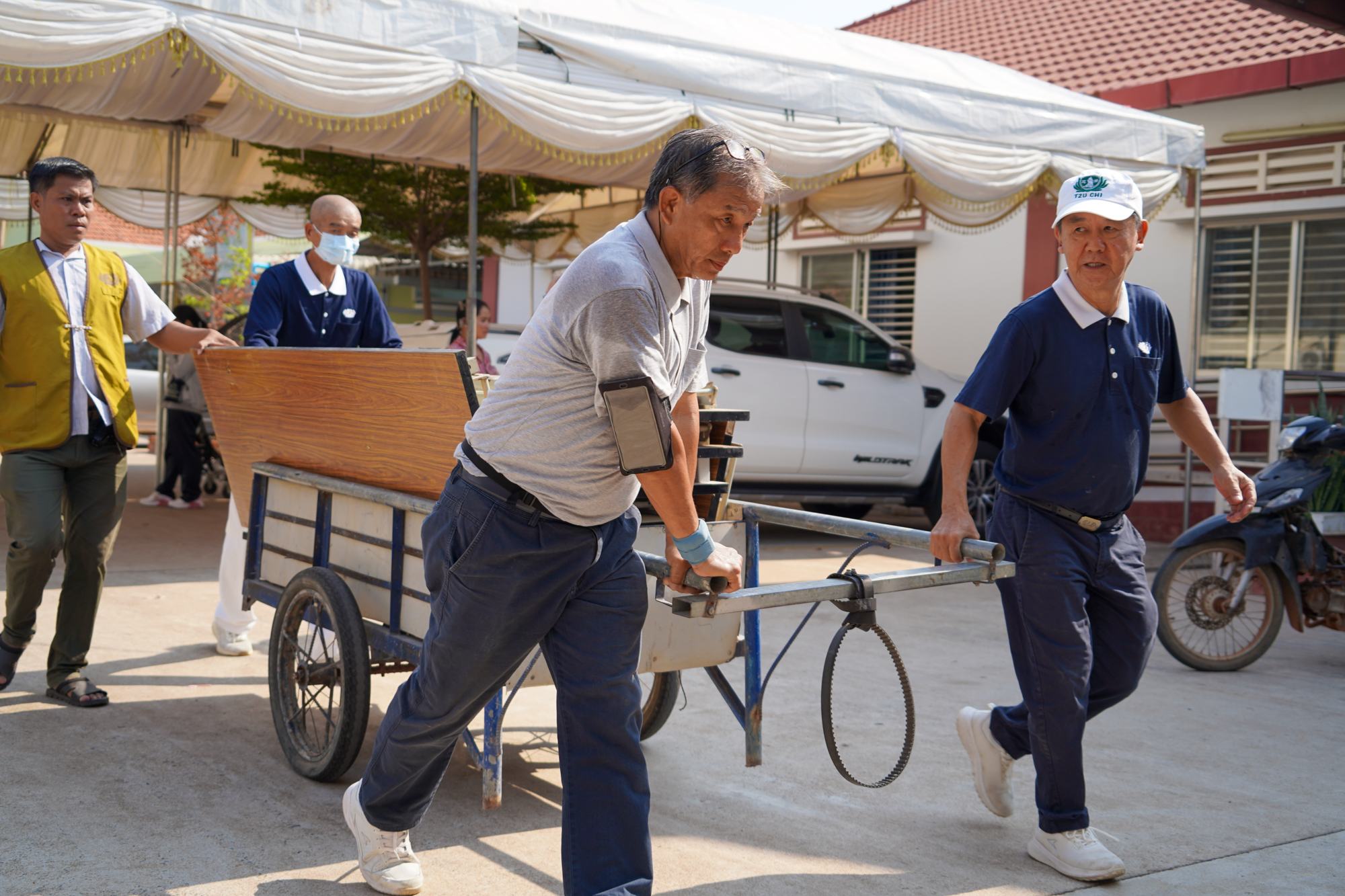 搬运器材十分耗力，志工们借助搬运车，将物品搬入室内。摄/ 潘晓彤