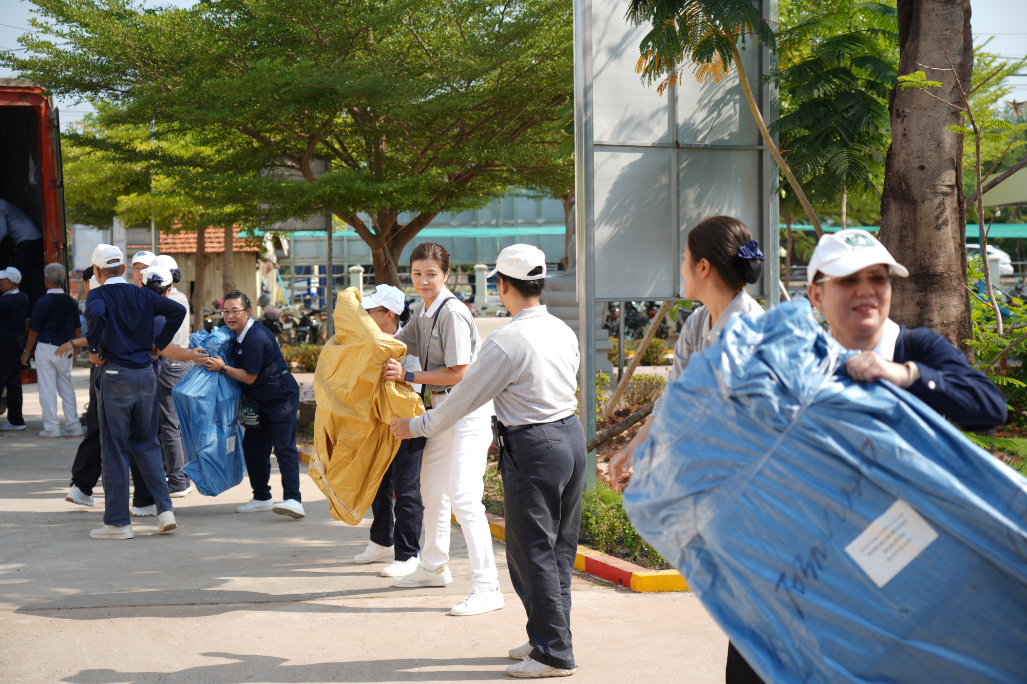 志工们以人龙接力方式，将布置所需的工具以及医疗器材，搬到帐篷区。摄/ 林春慧