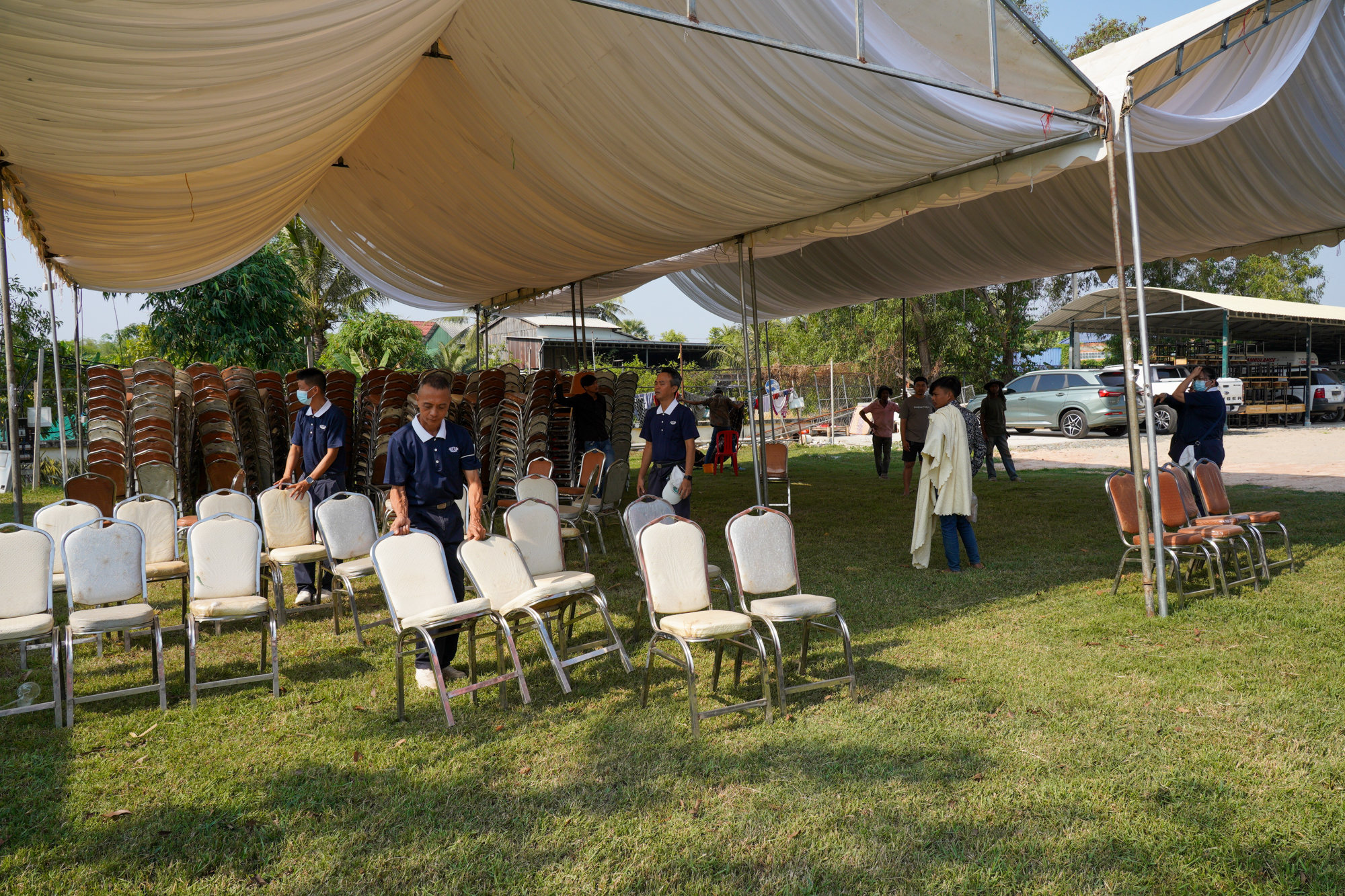 在酷热的天气下，志工们毫不计较付出，将一片空地转变为“就诊等候区”。摄/ 林春慧